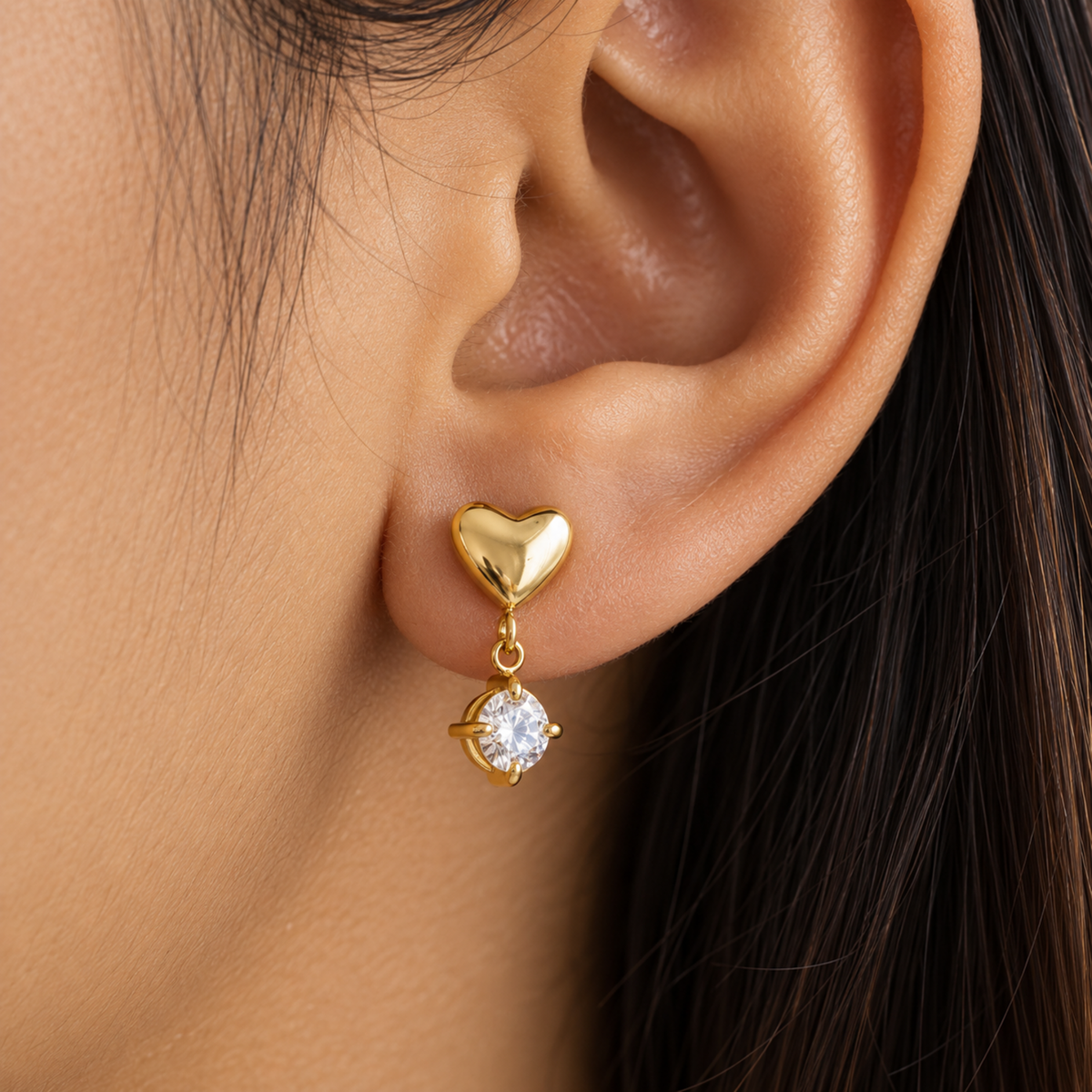Alina gold heart drop earrings for women with sparkling round crystal stones and pvd gold plated on a model ear