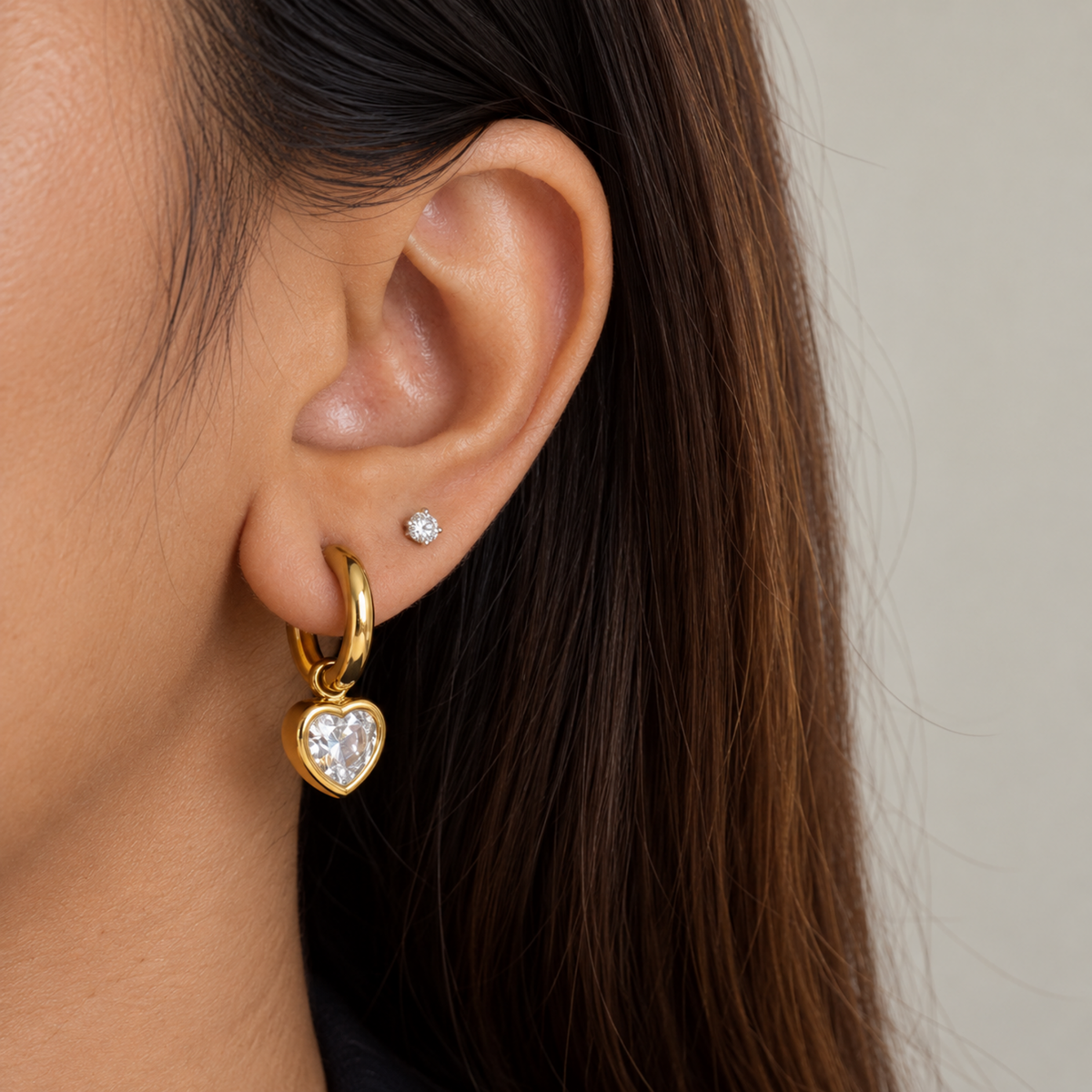 A close view of a Gold heart crystal hoop earrings for women with sparkling heart-shaped drops and PVD gold plated finish