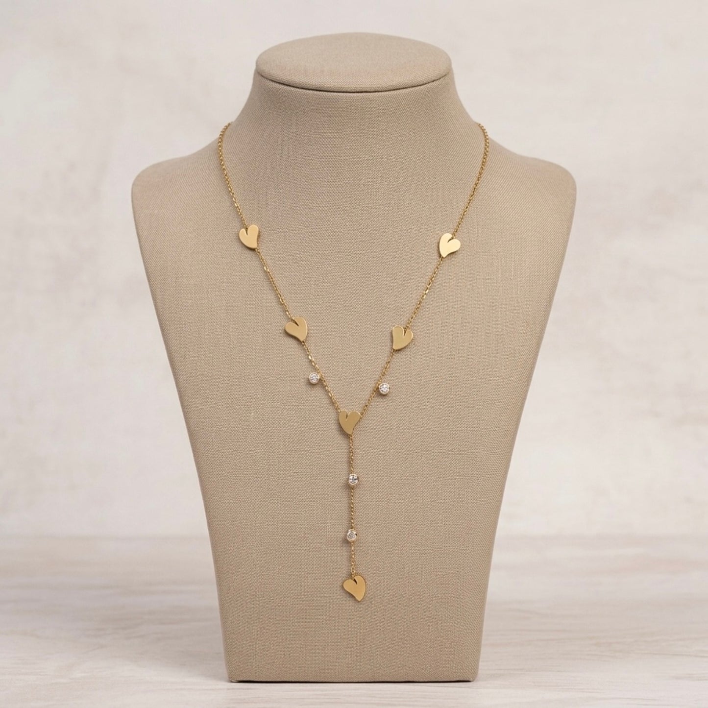 A gold-plated stainless steel Y-shaped chain necklace for women featuring minimalist heart charms and small round crystals