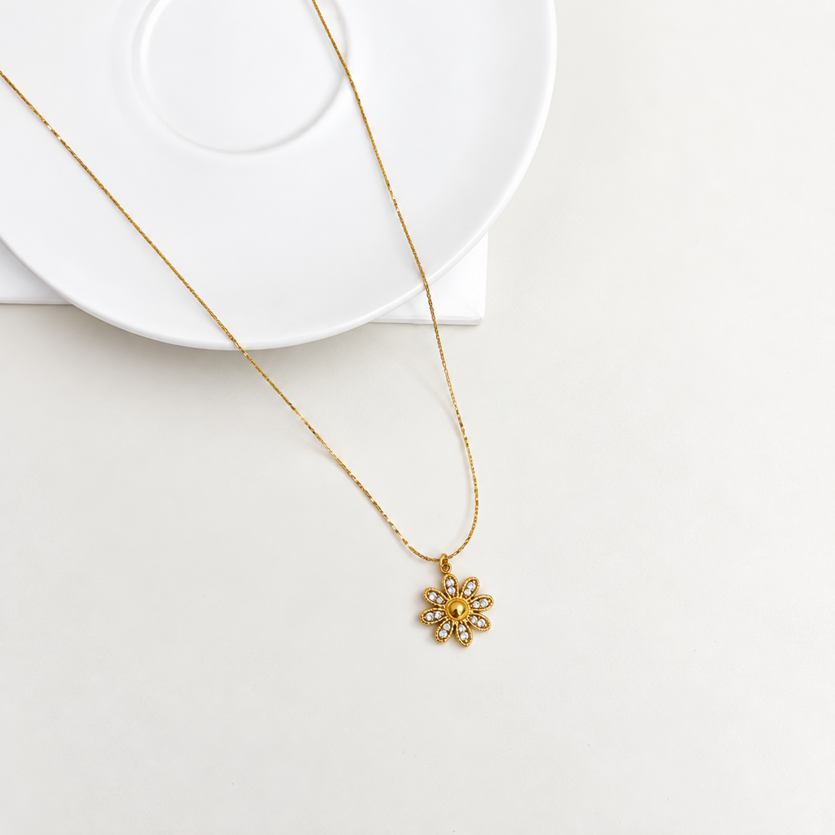 Dahlia Floral Crystal Pendant Necklace with a gold-tone flower pendant and clear crystal accents.