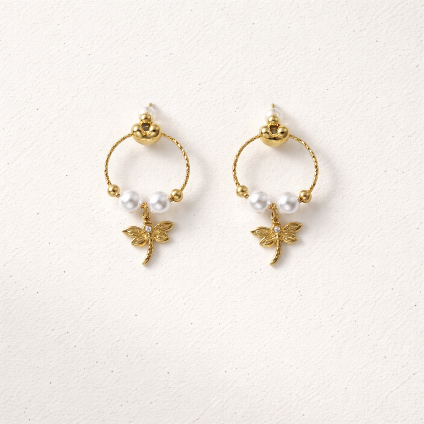 A pair of gold-plated earrings for women featuring a detailed dragonfly charm and three white pearls