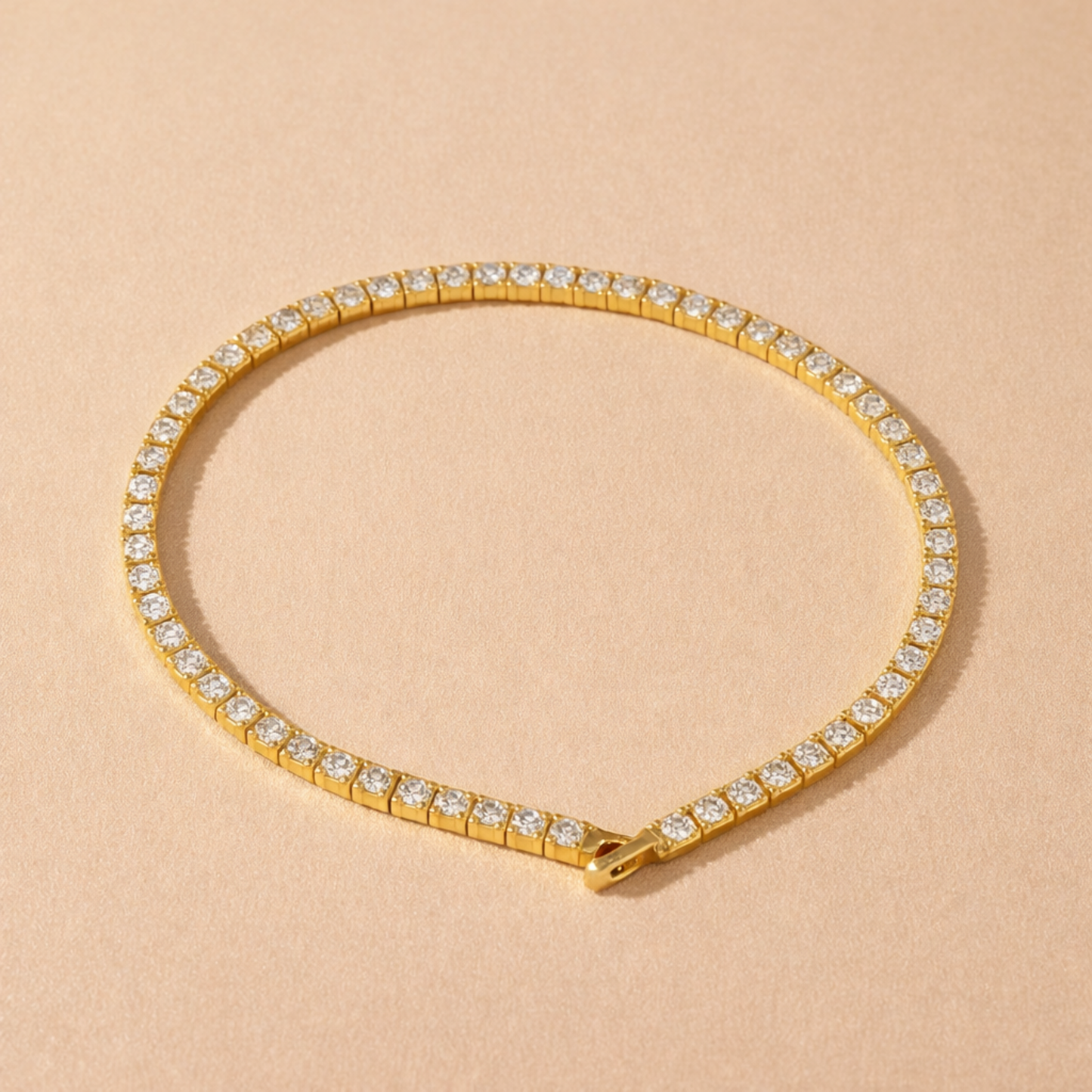 A gold-plated adjustable tennis bracelet for women on a cream background