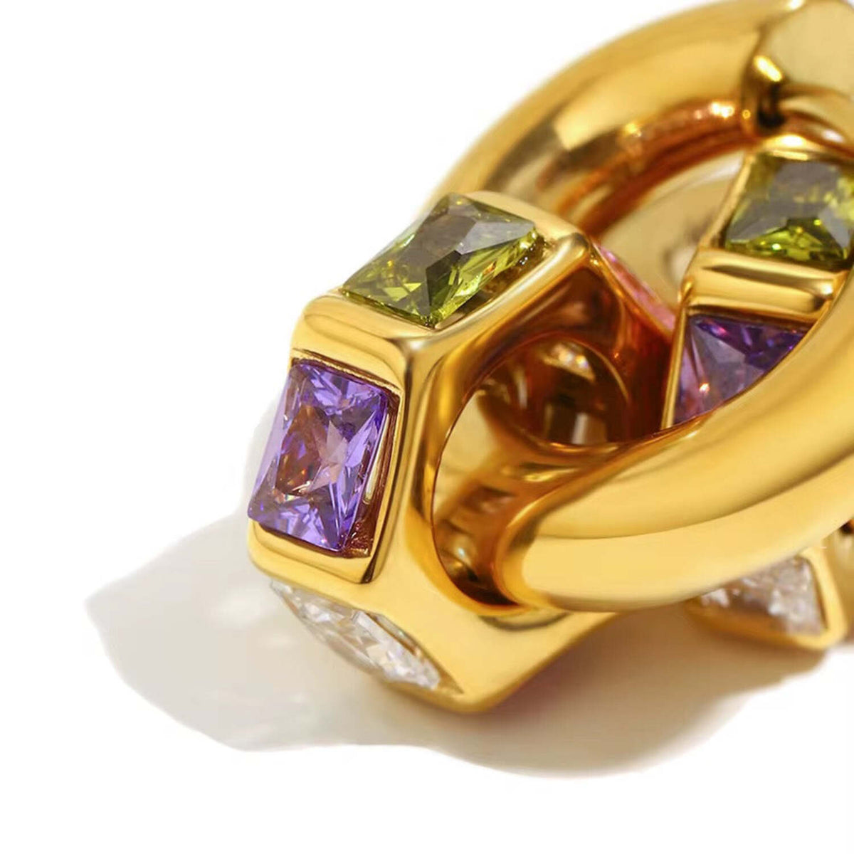 Gold ring with colorful gemstones on a white background