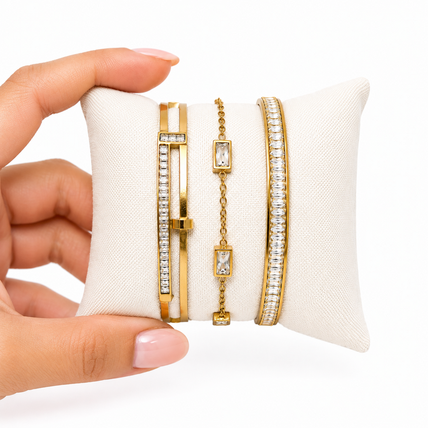 A close-view of a premium three-piece gold-plated bracelet stack for women featuring two geometric crystal station bangles and a central multi-cut crystal statement chain bracelet.