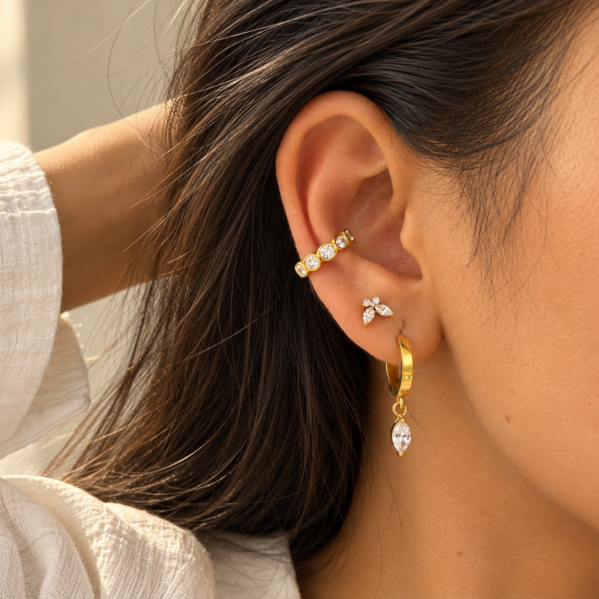 Gold-tone Crystal Ear Cuff with multiple clear faceted crystals in rounded settings, on a model