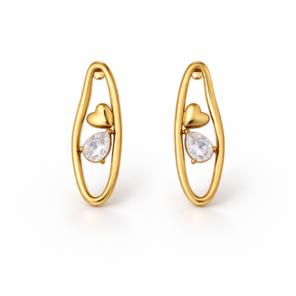 A pair of gold-plated organic-shaped stud earrings for women featuring a small golden heart and a pear-cut crystal inside a golden loop, shown on a white background.