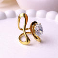 A bold and artistic gold plated adjustable statement ring for women featuring a large round white stone set in a sculptural, wavy gold-tone band on a white background