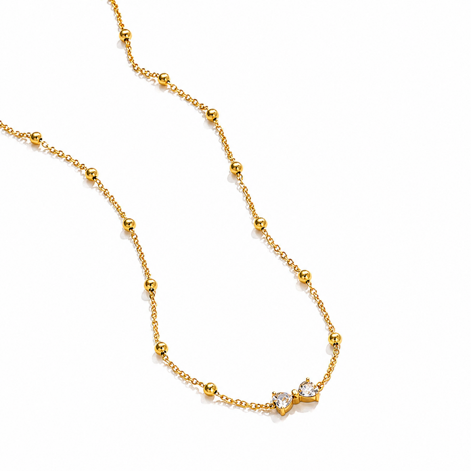 A gold-plated stainless steel chain for women featuring small gold beads and a central crystal bow charm