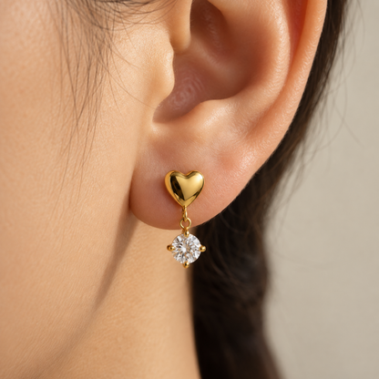 A close-view of a Alina gold heart drop earrings for women with sparkling round crystal stones and pvd gold plated
