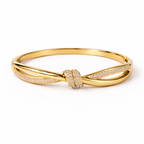 A high-end gold-plated knot bangle for women featuring a sparkling white stones central knot and a double-band cross-over design on a white background