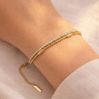 A dual-layer gold-plated bracelet for women featuring a sparkling crystal tennis strand and a geometric box chain shown on a model hand