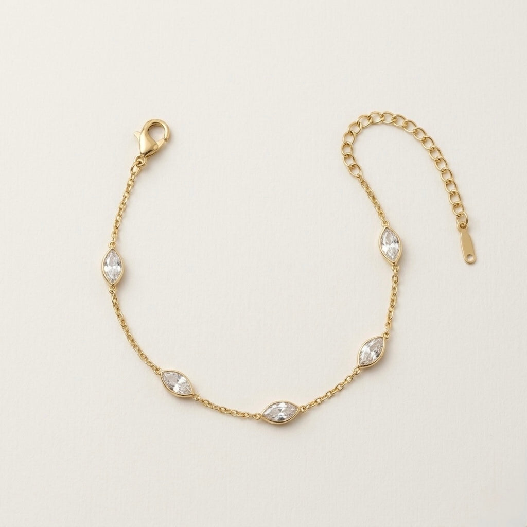 A dainty gold-plated chain bracelet for women featuring clear marquise-cut stone stations, shown on a clean off-white background