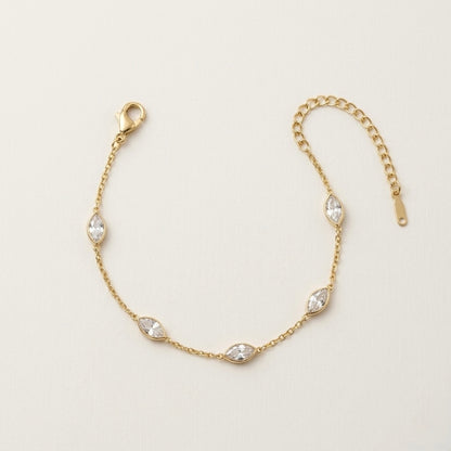 A dainty gold-plated chain bracelet for women featuring clear marquise-cut stone stations, shown on a clean off-white background