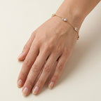 A dainty gold-plated chain bracelet for women featuring clear marquise-cut stone stations, shown on a model