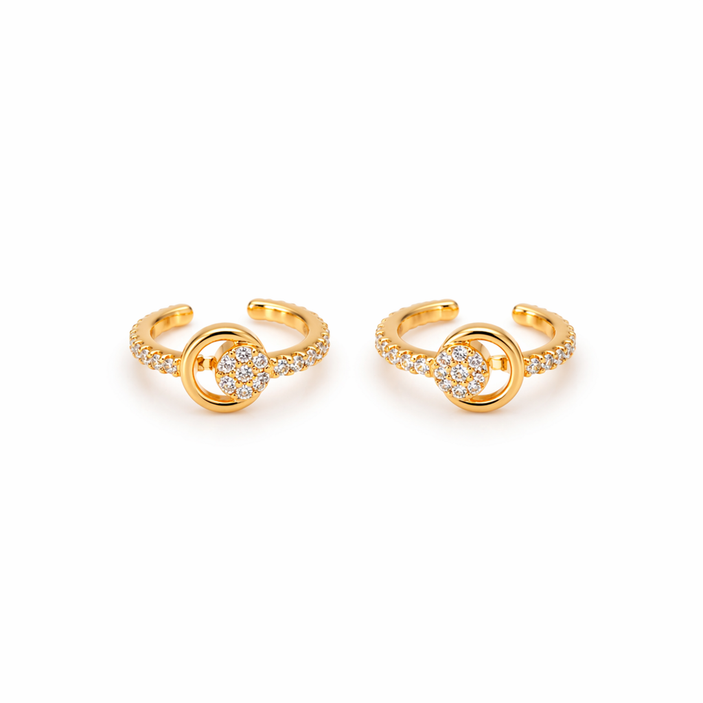 A pair of gold-plated ear cuffs for women featuring five brilliant-cut stones, shown on a textured white surface.