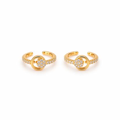 A pair of gold-plated ear cuffs for women featuring five brilliant-cut stones, shown on a textured white surface.