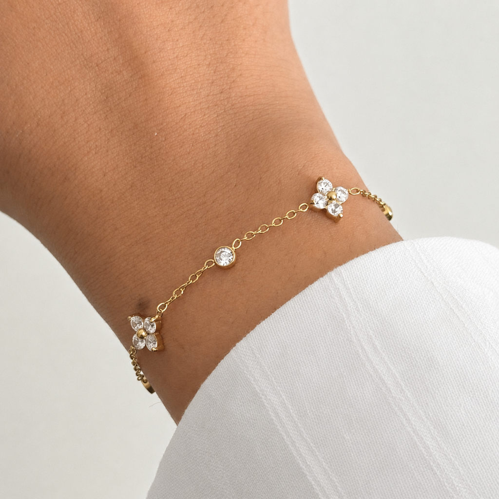 A close-view of a gold-plated chain bracelet for women featuring alternating crystal floral clusters and round bezel-set stones.