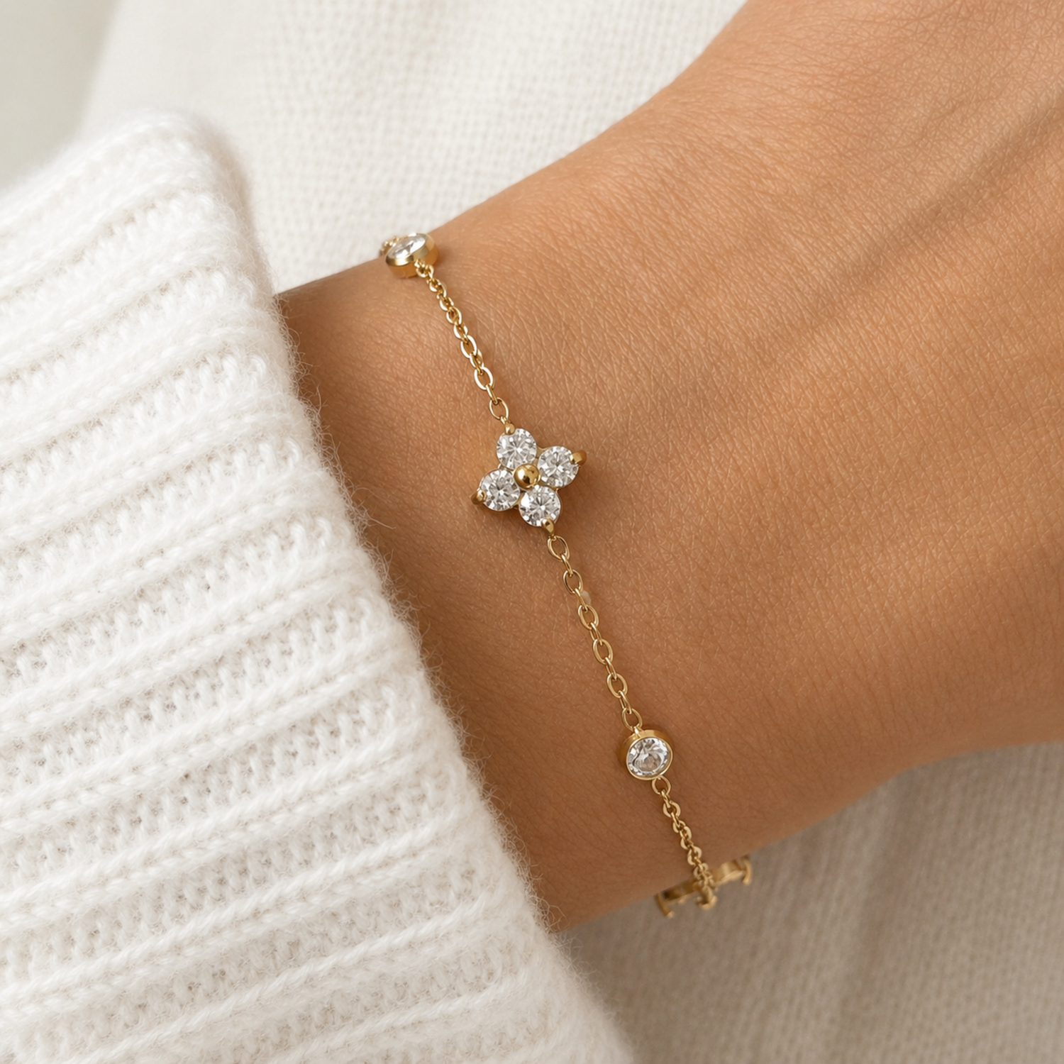 A gold-plated chain bracelet for women featuring alternating crystal floral clusters and round bezel-set stones, shown on a model