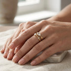 A gold plated adjustable ring for women with a double-band design featuring a central marquise-cut white stone on a model hand