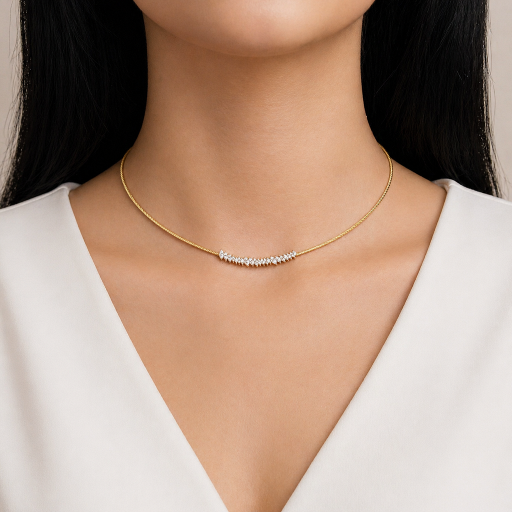 A gold-plated stainless steel chain for women featuring a twisted cable design and an asymmetrical cluster of marquise-cut crystals, shown on a model