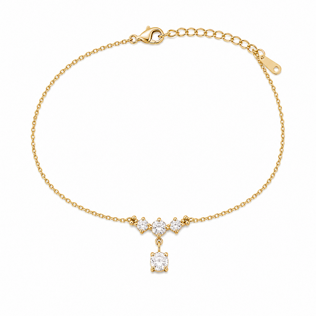 A delicate gold-plated ladies bracelet featuring a cluster of four brilliant-cut crystals and a dangling drop stone