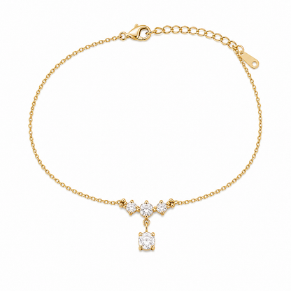 A delicate gold-plated ladies bracelet featuring a cluster of four brilliant-cut crystals and a dangling drop stone