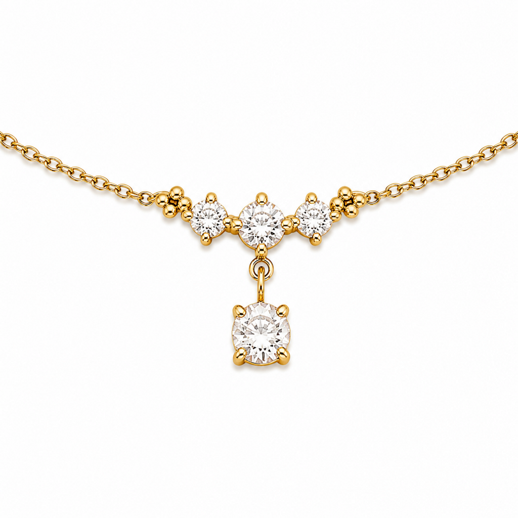 A close-view of a delicate gold-plated ladies bracelet featuring a cluster of four brilliant-cut crystals and a dangling drop stone.