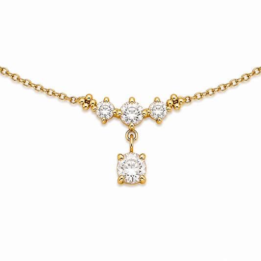 A close-view of a delicate gold-plated ladies bracelet featuring a cluster of four brilliant-cut crystals and a dangling drop stone.