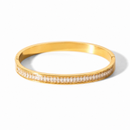 A close-view of a gold-plated hinged bangle for women featuring a continuous row of channel-set baguette crystals with a secure side-clasp