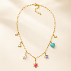 A gold-plated stainless steel chain for women featuring paperclip links and seven colorful charms including a pearl, heart, and sun