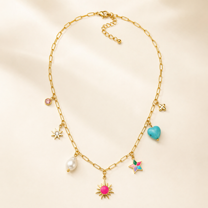 A gold-plated stainless steel chain for women featuring paperclip links and seven colorful charms including a pearl, heart, and sun