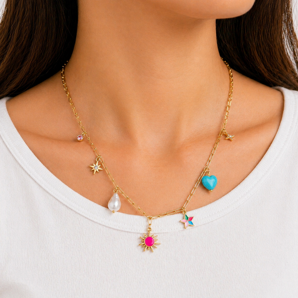 A gold-plated stainless steel chain for women featuring paperclip links and seven colorful charms including a pearl, heart, and sun, shown on a model