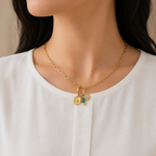 A gold-plated stainless steel chain for women featuring paperclip links and a carabiner clasp with three hanging charms, including a turquoise stone and an evil eye, shown on a model