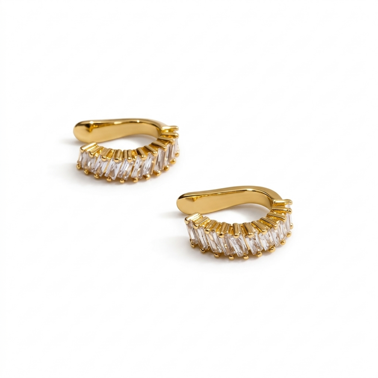 A gold-plated ear cuff for women featuring brilliant prong-set baguette-cut white stones, shown as a pair on a white background