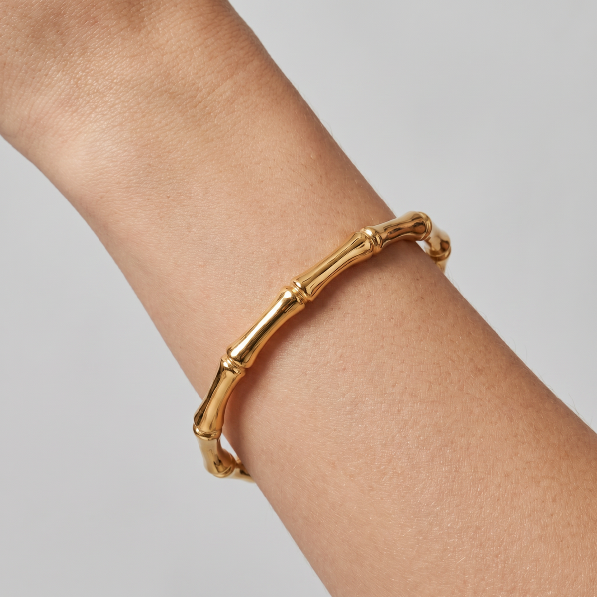 Bamboo Gold Bangle Bracelet with sculpted, segmented bamboo-inspired links and a gold-plated finish, on a model