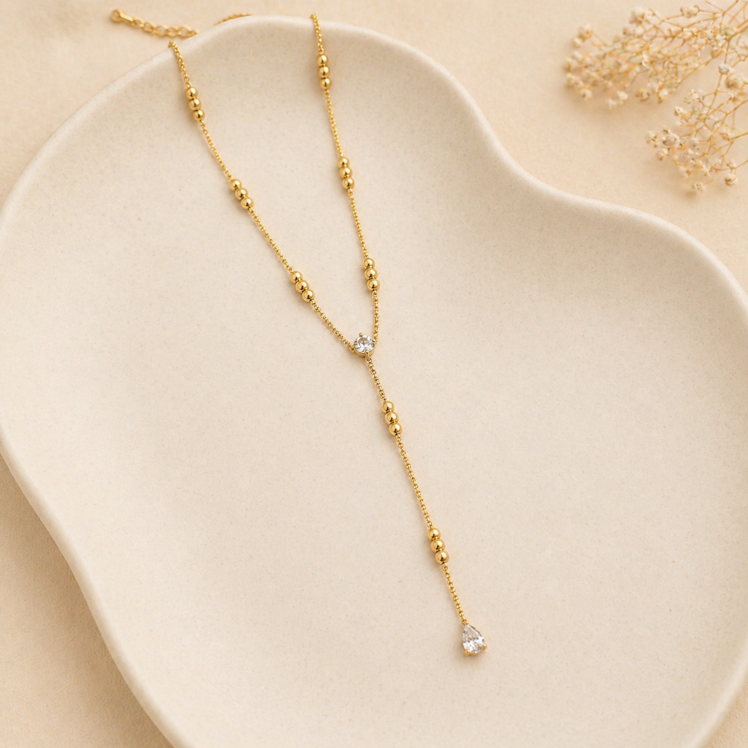 A gold-plated stainless steel chain for women in a Y-drop lariat style featuring delicate beads and crystal accents