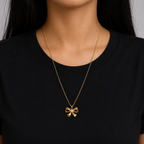 A gold-plated stainless steel chain for women featuring a golden bow pendant with a central pearl, shown on a model