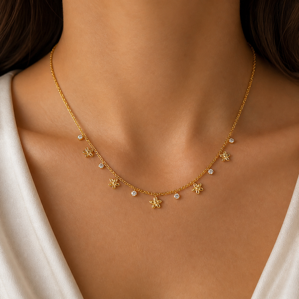 A gold-plated stainless steel chain for women featuring a woven texture with dangling gold flowers and round crystal charms, shown on a model