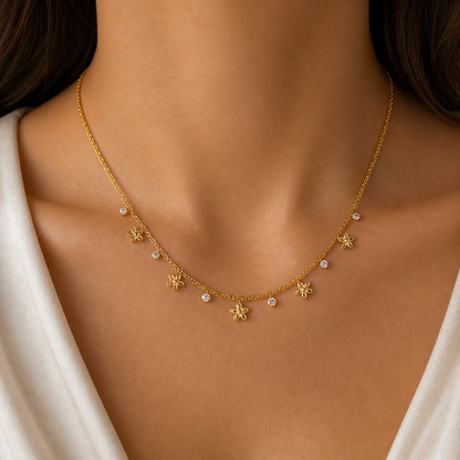 A gold-plated stainless steel chain for women featuring a woven texture with dangling gold flowers and round crystal charms, shown on a model