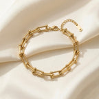Gold chain bracelet on a beige fabric background