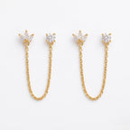A pair of gold-plated ear chain earrings for women featuring a marquise-cut floral stud and a round white stone stud connected by a delicate gold chain on a white background