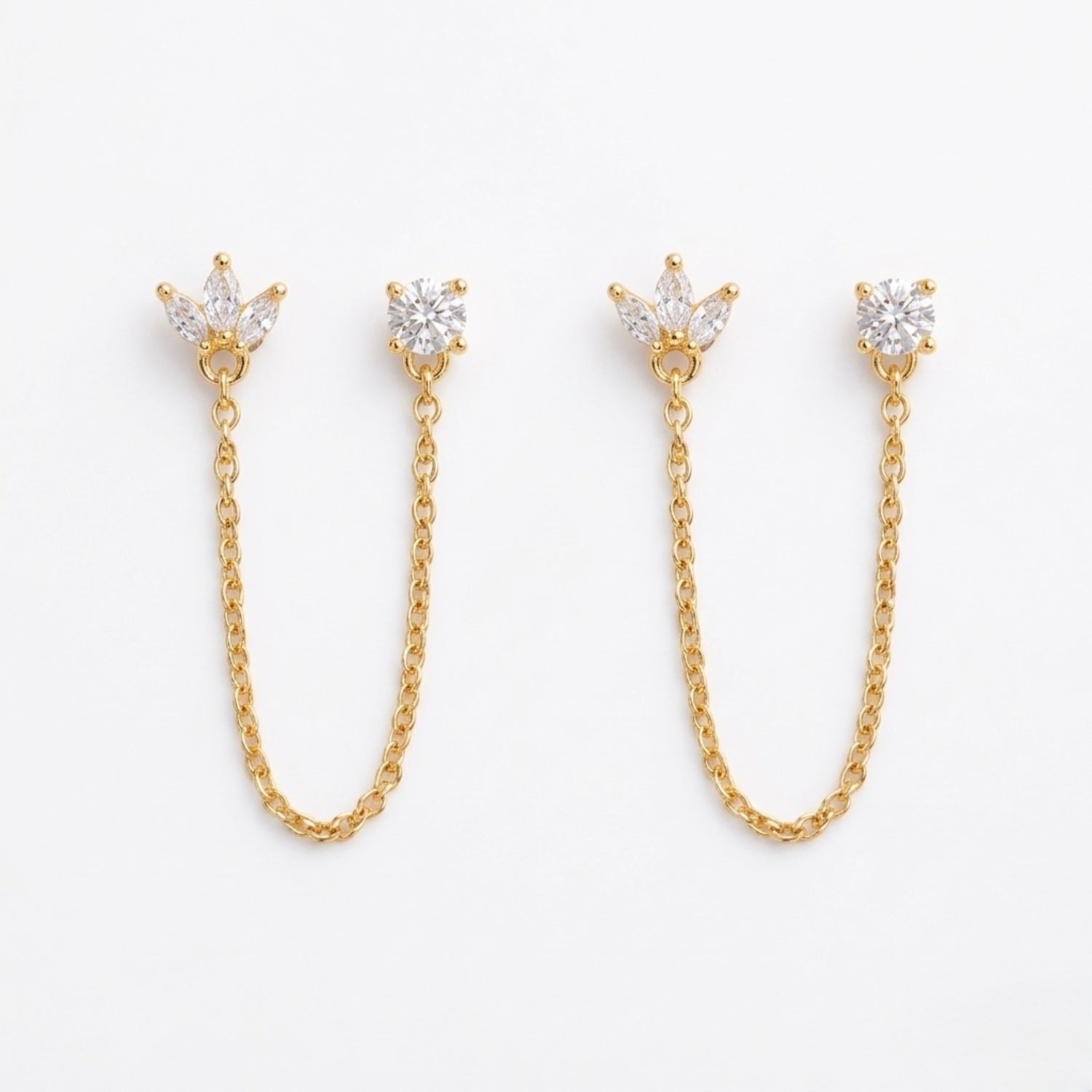 A pair of gold-plated ear chain earrings for women featuring a marquise-cut floral stud and a round white stone stud connected by a delicate gold chain on a white background