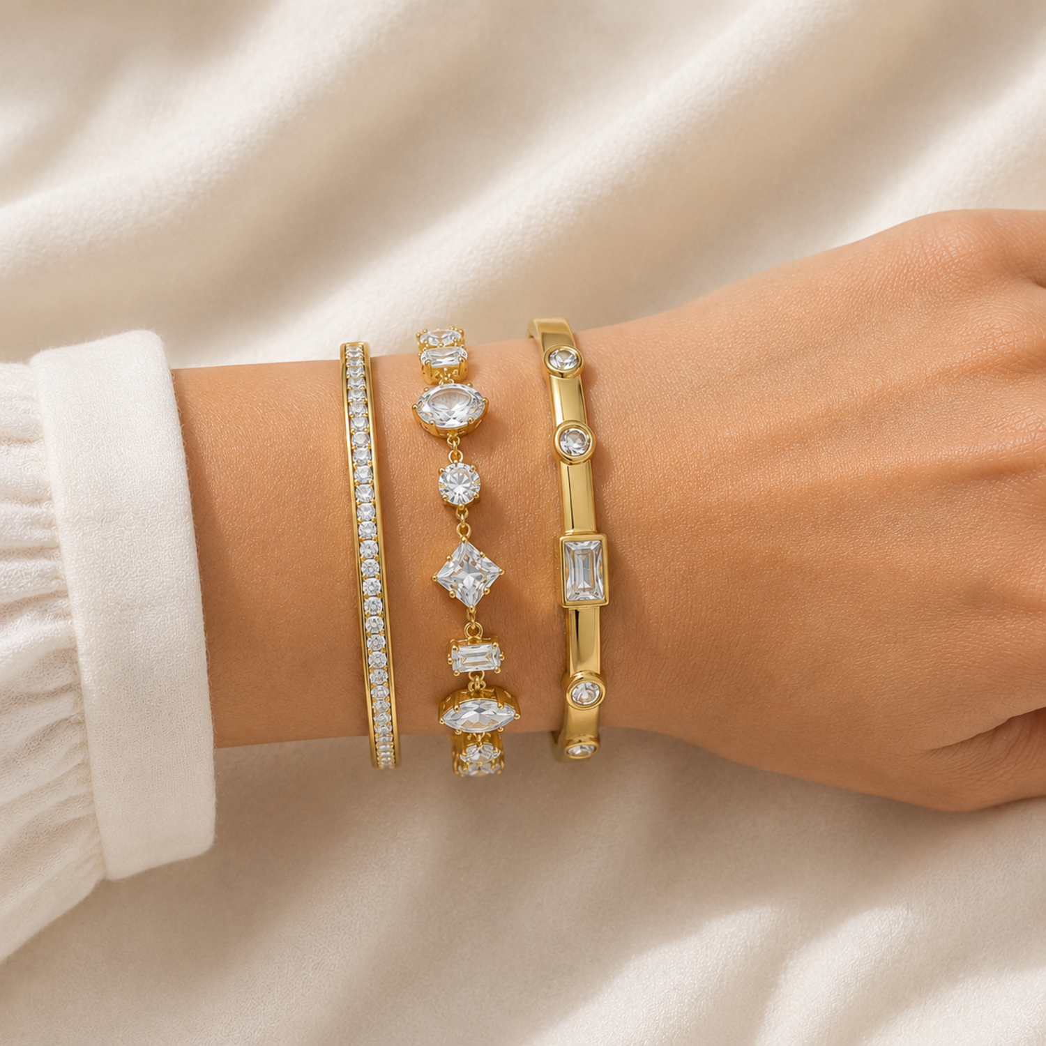 A close-view of a three-piece gold-plated bracelet stack for women featuring an iced eternity bangle, a multi-cut geometric crystal chain bracelet, and a polished bezel-set crystal bangle.
