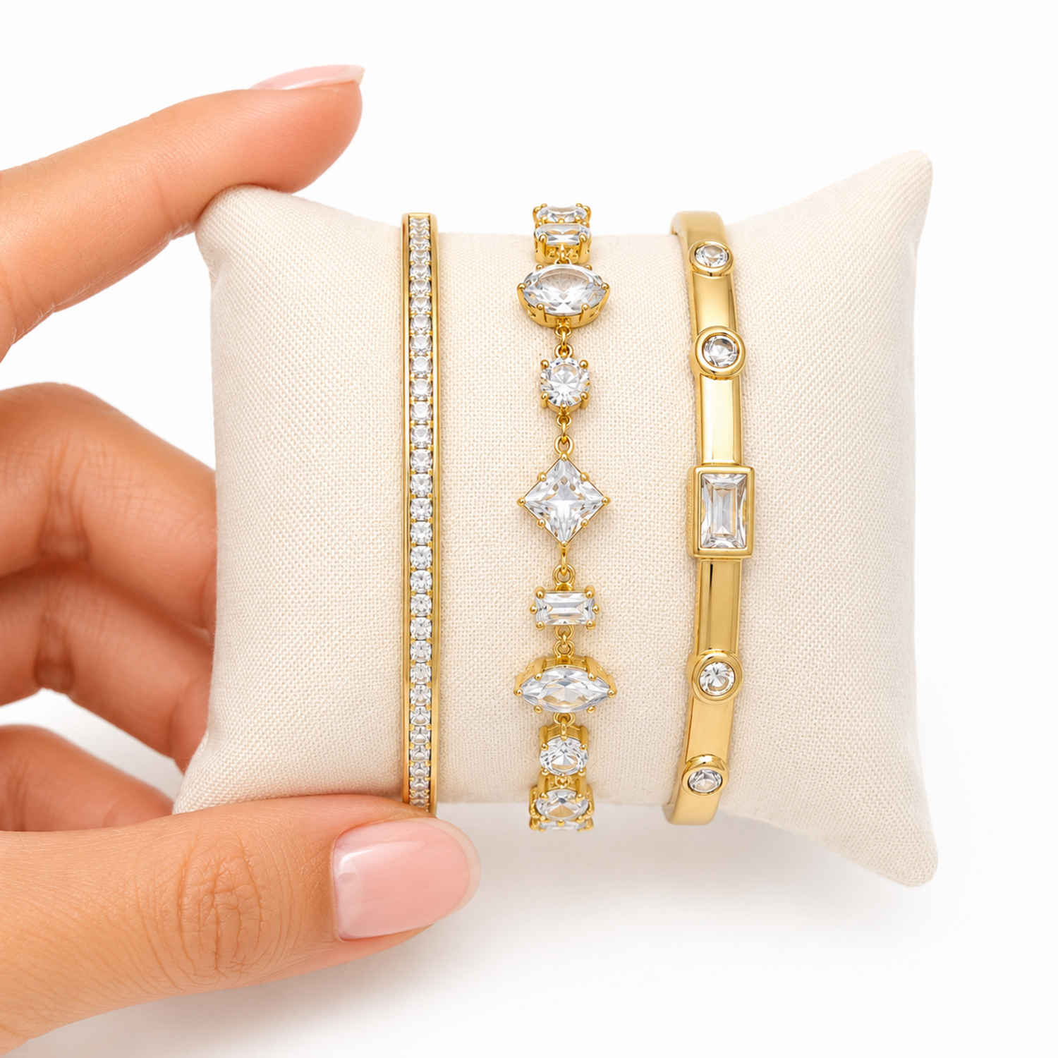 A three-piece gold-plated bracelet stack for women featuring an iced eternity bangle, a multi-cut geometric crystal chain bracelet, and a polished bezel-set crystal bangle.