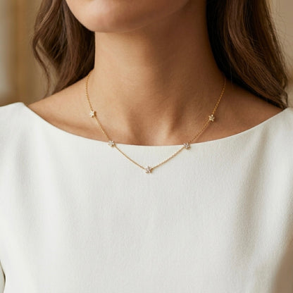 A gold-plated stainless steel chain for women featuring multiple small crystal-encrusted star stations, shown on a model