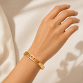 A gold-plated dual-band bracelet for women featuring floating star motifs, round crystals, and a square solitaire, shown on a model