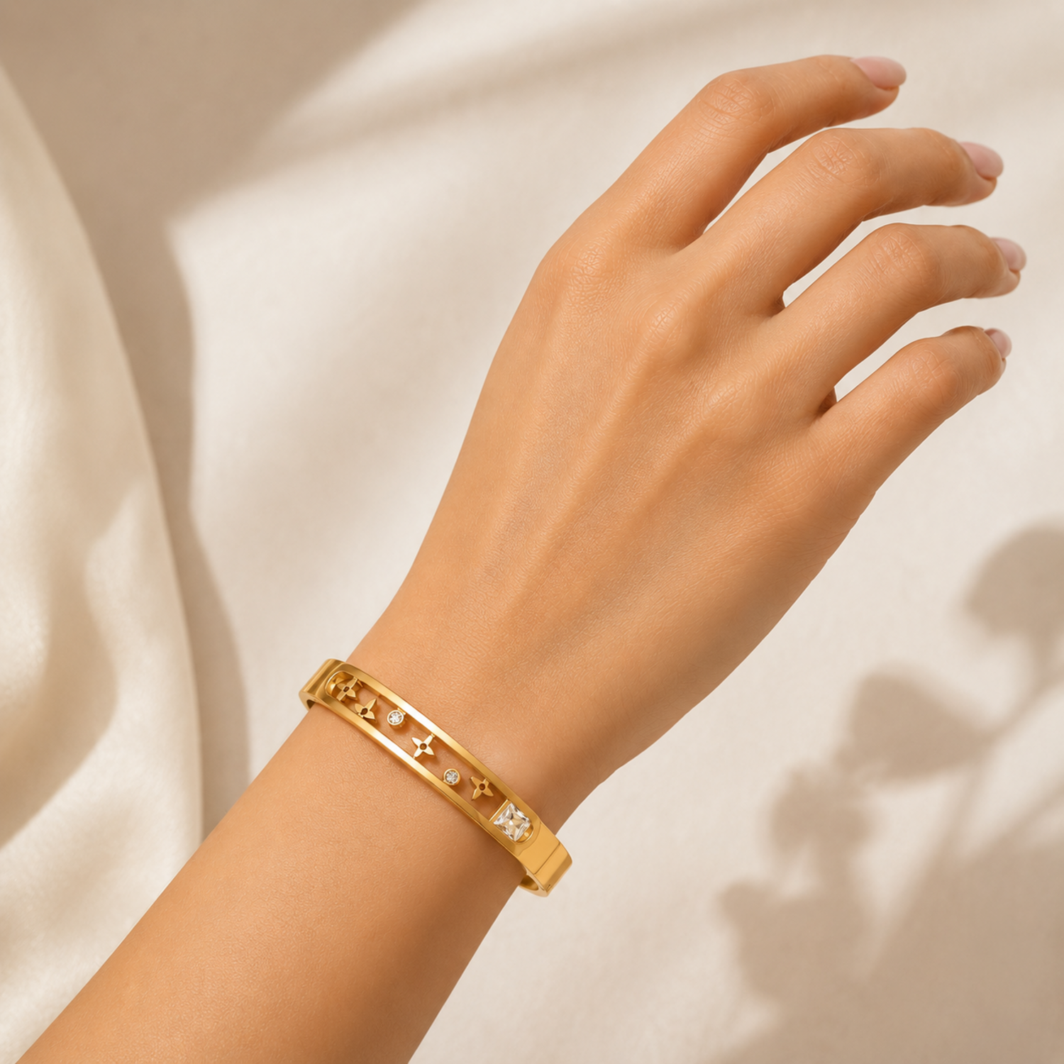 A gold-plated dual-band bracelet for women featuring floating star motifs, round crystals, and a square solitaire, shown on a model