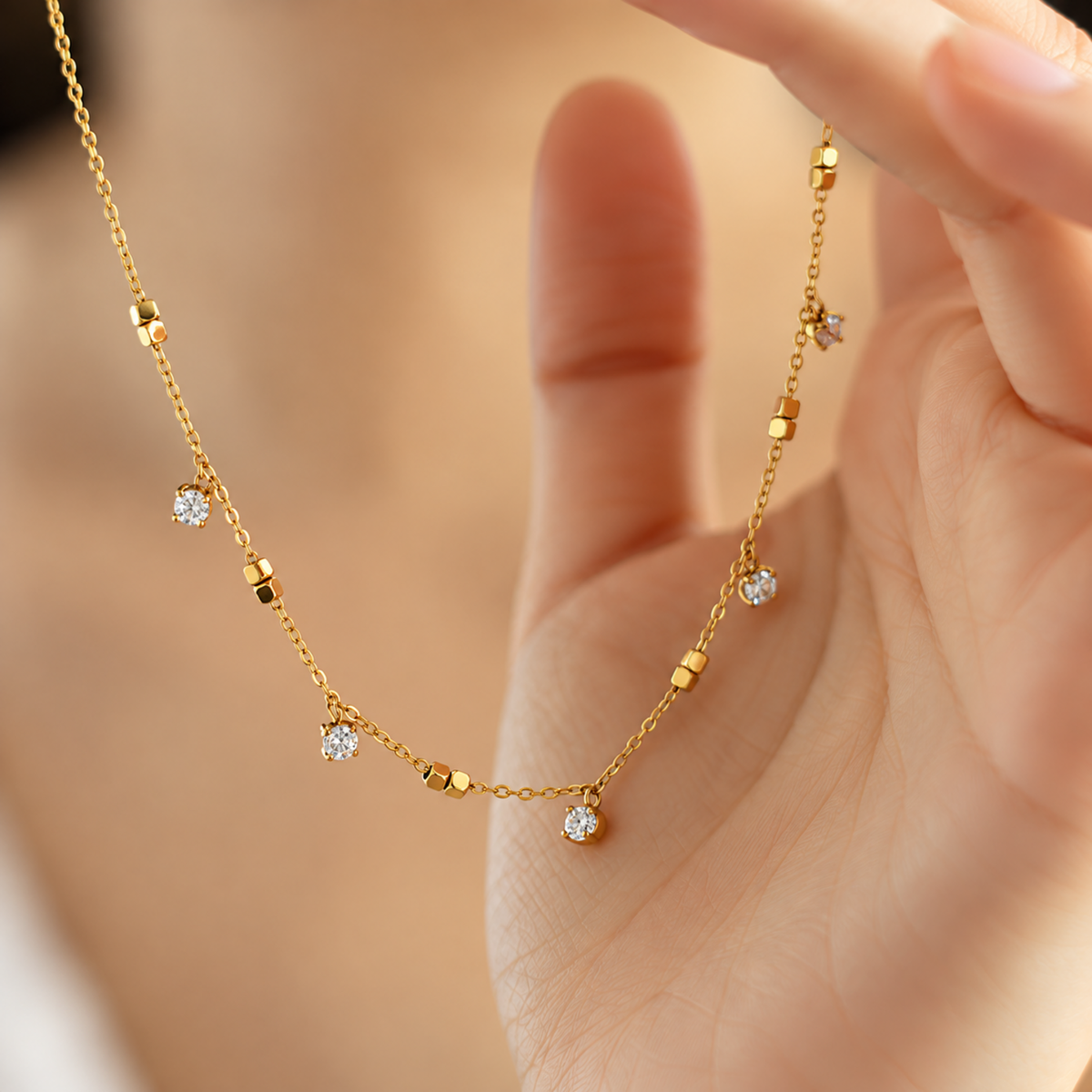 A close-view of a Crystal Station Necklace with clear crystal accents and gold-tone square bead details on a delicate chain.