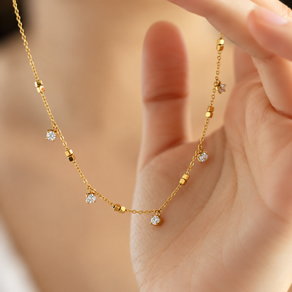 A close-view of a Crystal Station Necklace with clear crystal accents and gold-tone square bead details on a delicate chain.