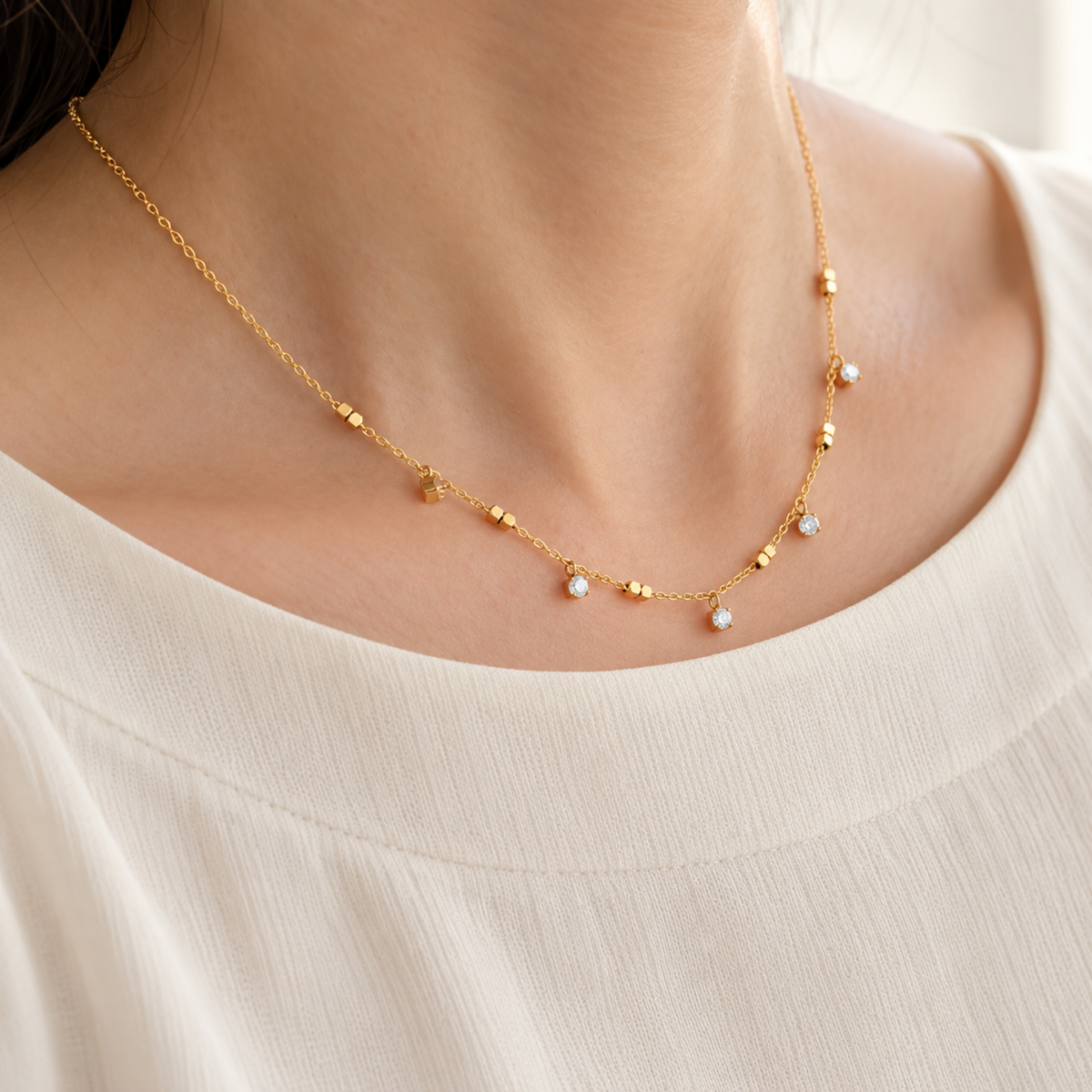 Crystal Station Necklace with clear crystal accents and gold-tone square bead details on a delicate chain, on a model